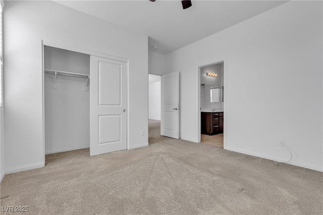 unfurnished bedroom featuring a ceiling fan, baseboards, carpet floors, a closet, and ensuite bathroom