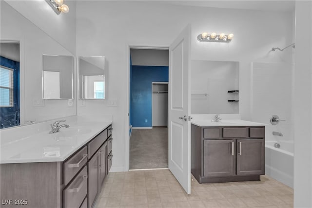 bathroom featuring shower / tub combination, a healthy amount of sunlight, two vanities, and a sink