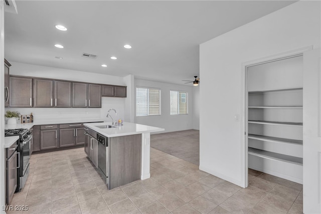 kitchen featuring a sink, light countertops, visible vents, and gas range oven