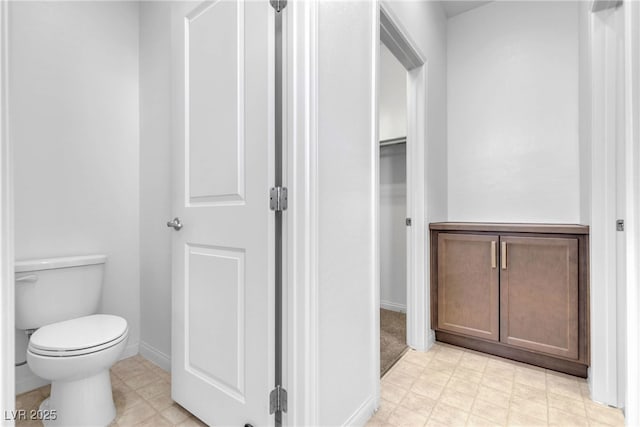 bathroom featuring tile patterned floors, toilet, and baseboards