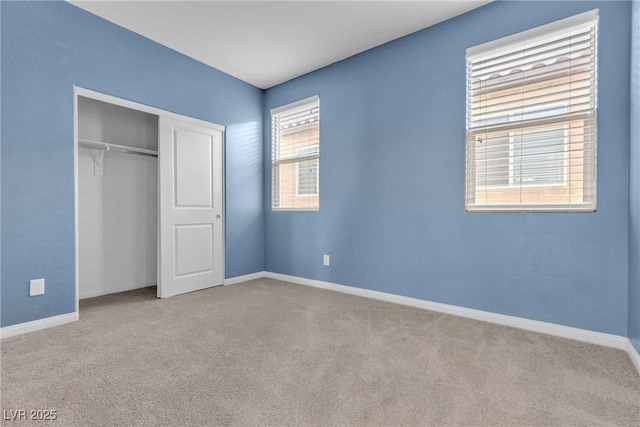 unfurnished bedroom featuring carpet, baseboards, and a closet