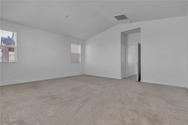 unfurnished room featuring visible vents, light carpet, baseboards, and vaulted ceiling