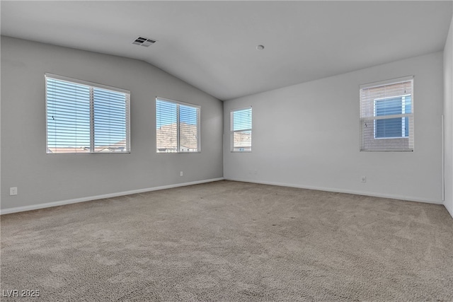 empty room featuring baseboards, visible vents, lofted ceiling, and carpet floors