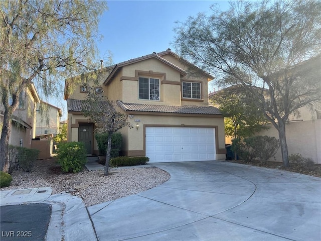 traditional-style home with a garage, concrete driveway, a tile roof, and stucco siding