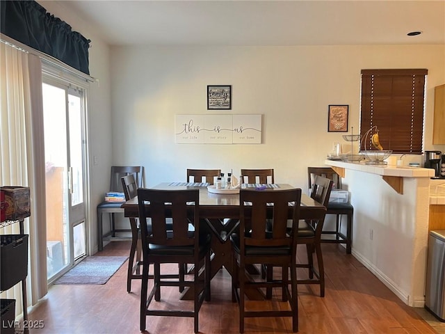 dining space featuring baseboards and wood finished floors