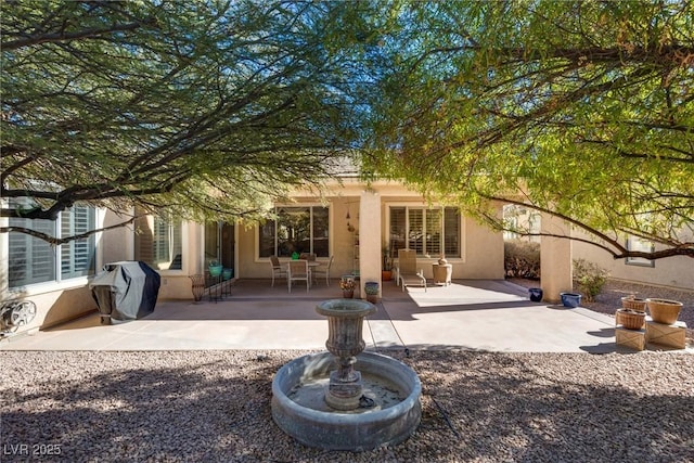 rear view of property featuring a patio area and stucco siding