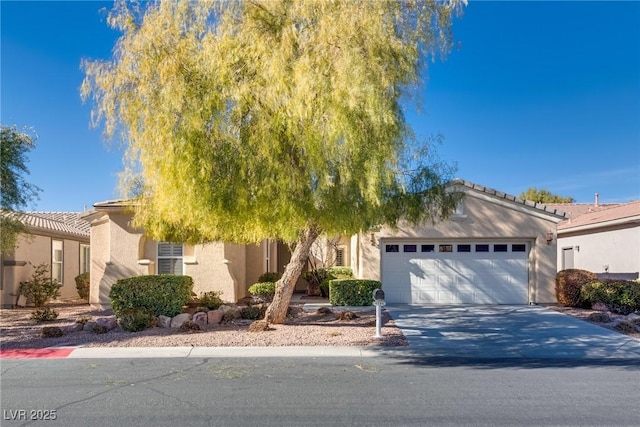 view of front of property with stucco siding, an attached garage, and concrete driveway