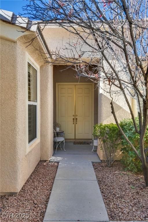 entrance to property featuring stucco siding