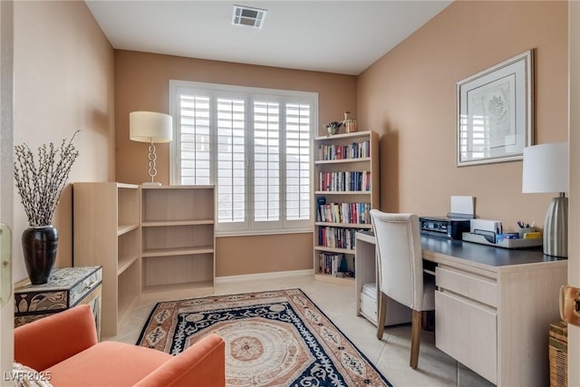 home office featuring light tile patterned flooring, a healthy amount of sunlight, visible vents, and baseboards