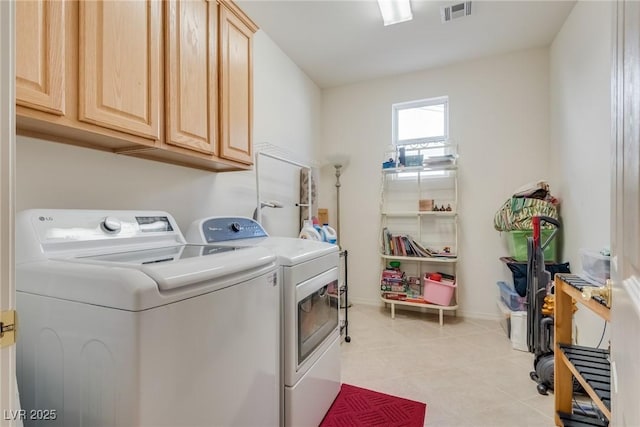 clothes washing area featuring baseboards, cabinet space, visible vents, and washing machine and clothes dryer