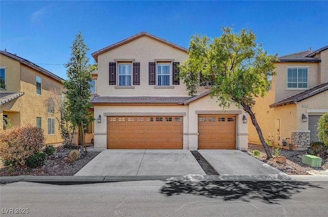 view of front of home featuring concrete driveway, an attached garage, a tiled roof, and stucco siding