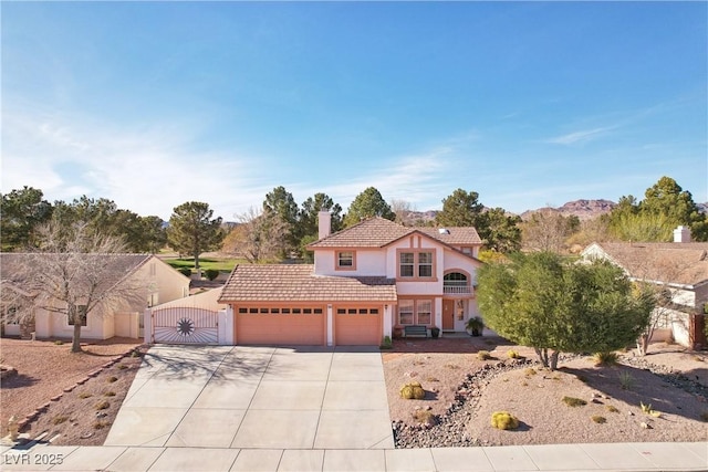 view of front facade featuring an attached garage, a tile roof, concrete driveway, a gate, and stucco siding