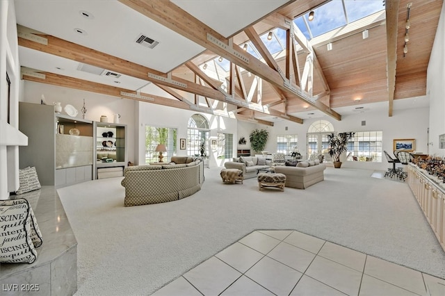 living room with light carpet, a skylight, visible vents, beamed ceiling, and high vaulted ceiling