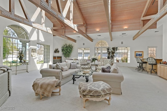 living area with high vaulted ceiling, carpet, beamed ceiling, and plenty of natural light