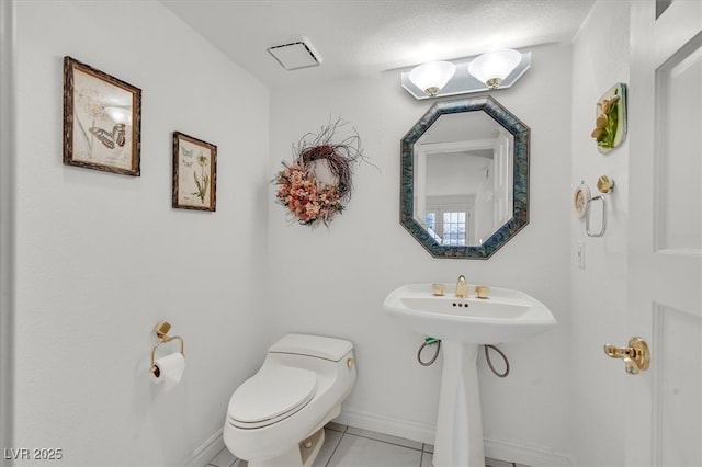 bathroom with tile patterned floors, toilet, and baseboards