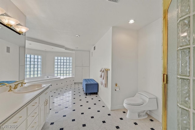 full bathroom featuring toilet, recessed lighting, vanity, baseboards, and a bathtub