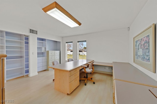 home office featuring light wood finished floors and visible vents