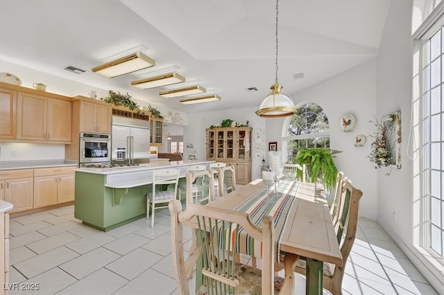 kitchen with light brown cabinets, visible vents, light countertops, appliances with stainless steel finishes, and a center island