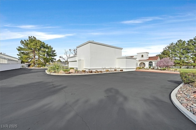 exterior space featuring aphalt driveway and stucco siding