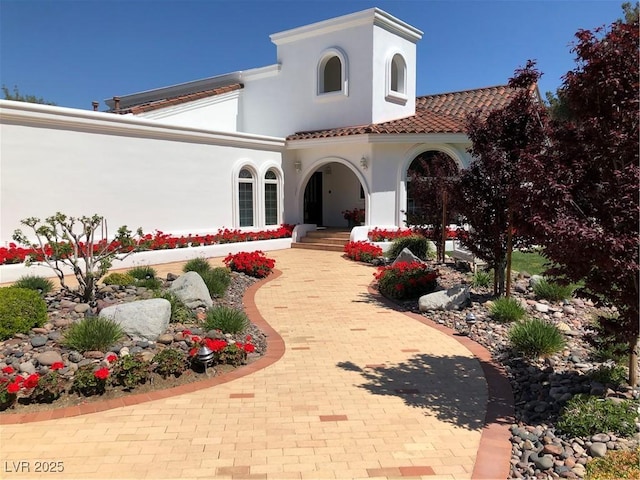 view of front of home with a tiled roof and stucco siding