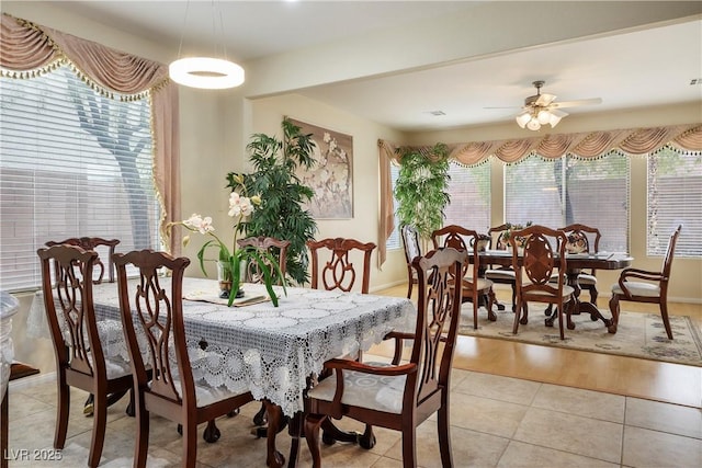 dining space with light tile patterned flooring and ceiling fan