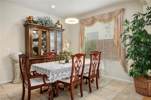 dining room featuring baseboards and light tile patterned floors