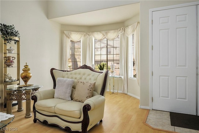 living area with light wood-type flooring and baseboards