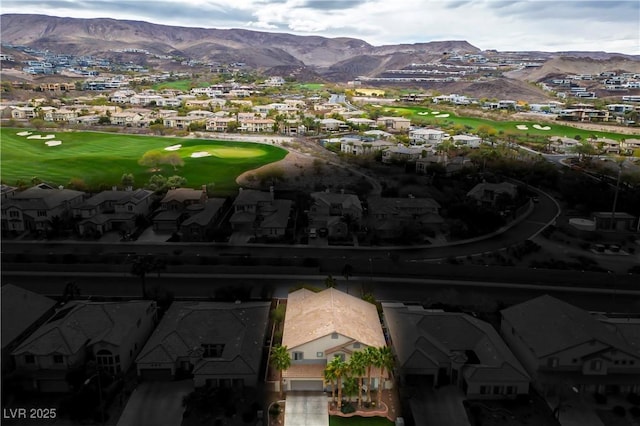 drone / aerial view featuring a residential view, view of golf course, and a mountain view