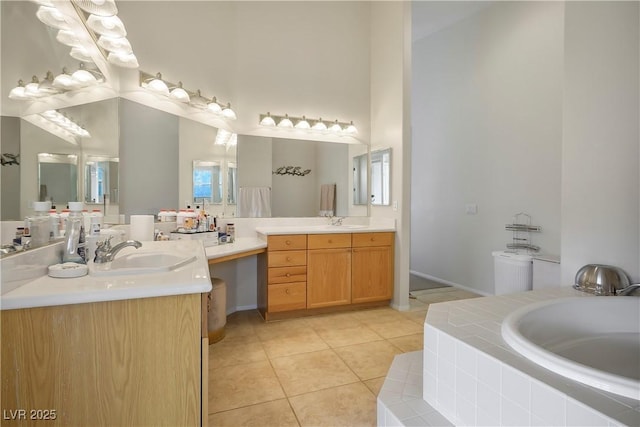 bathroom with a towering ceiling, a garden tub, vanity, and tile patterned floors