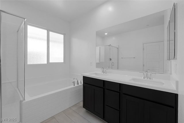 full bathroom featuring a garden tub, double vanity, a sink, and a shower stall