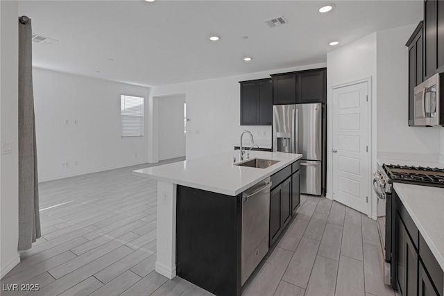 kitchen featuring visible vents, wood tiled floor, appliances with stainless steel finishes, and a sink