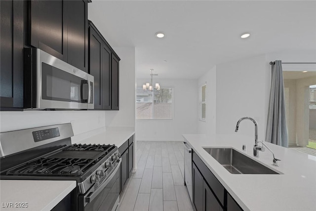 kitchen with stainless steel appliances, wood finish floors, light countertops, and a sink