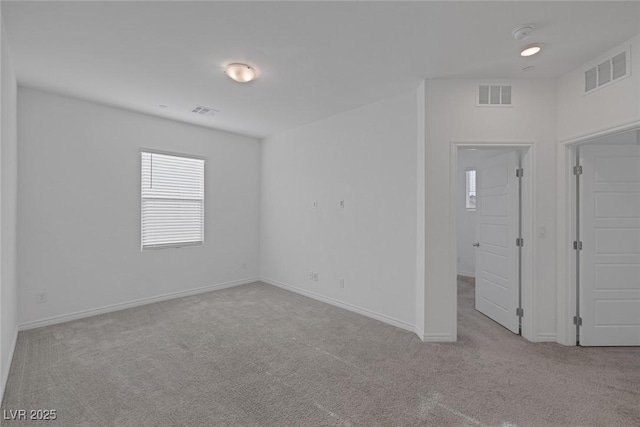 unfurnished bedroom with carpet floors, baseboards, and visible vents