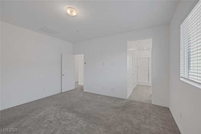 spare room with carpet and baseboards