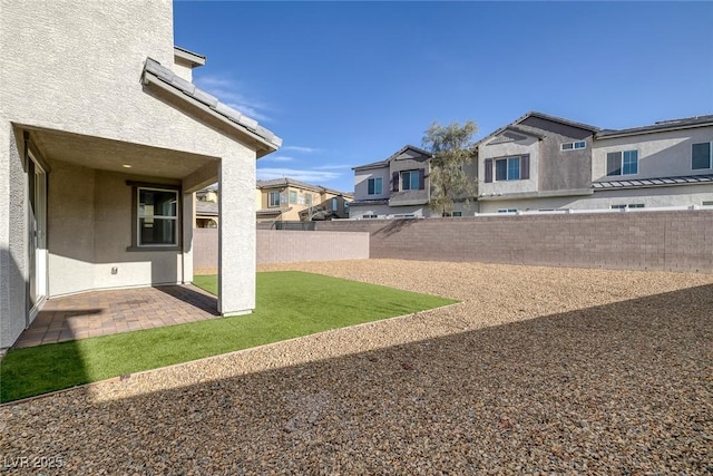 view of yard with a fenced backyard, a residential view, and a patio