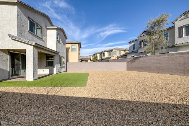 view of yard with a residential view, a patio area, and a fenced backyard