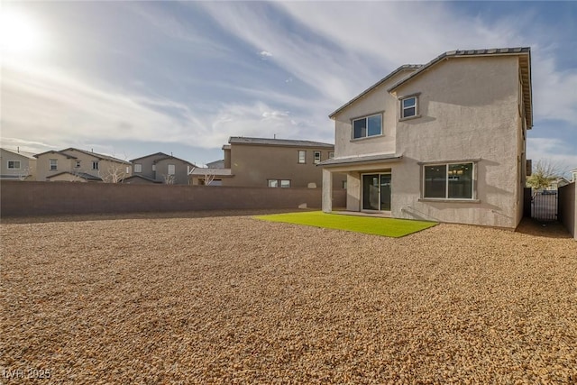 back of property featuring a fenced backyard and stucco siding