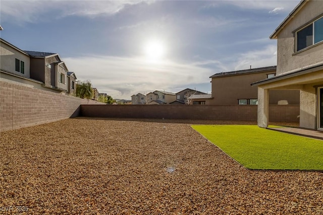 view of yard featuring a fenced backyard and a residential view