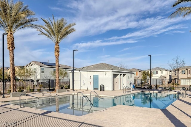 community pool with a patio area, a residential view, and fence