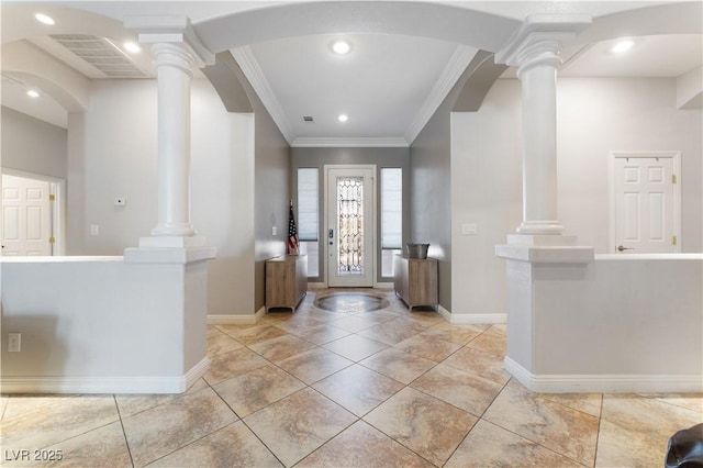 foyer entrance with baseboards, ornamental molding, and ornate columns