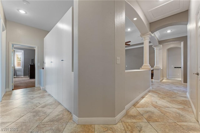 corridor featuring arched walkways, light tile patterned flooring, decorative columns, and recessed lighting