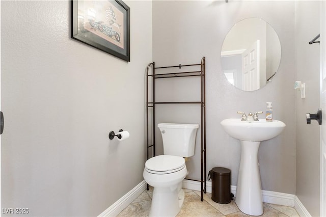 bathroom with toilet, tile patterned flooring, and baseboards