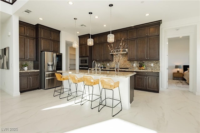 kitchen with marble finish floor, a kitchen bar, visible vents, and stainless steel appliances