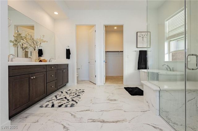 bathroom with double vanity, a stall shower, toilet, marble finish floor, and recessed lighting