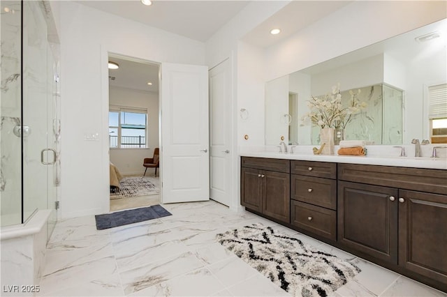 ensuite bathroom featuring marble finish floor, connected bathroom, a marble finish shower, and a sink