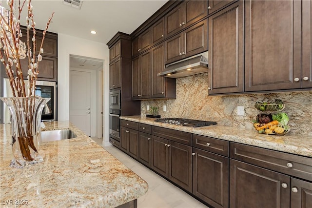 kitchen featuring under cabinet range hood, stainless steel appliances, visible vents, dark brown cabinets, and decorative backsplash