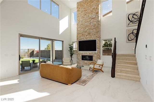 living room with marble finish floor, a fireplace, and stairway