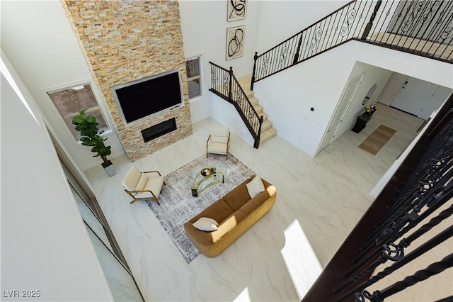 living room with marble finish floor, stairway, and a high ceiling