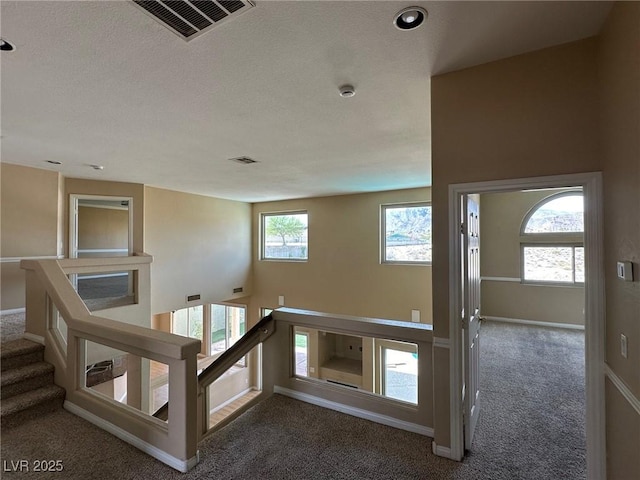 stairs with carpet, visible vents, and baseboards