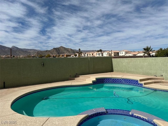 view of pool featuring a pool with connected hot tub and a mountain view